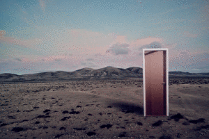 Girl stepping out of a door in the desert